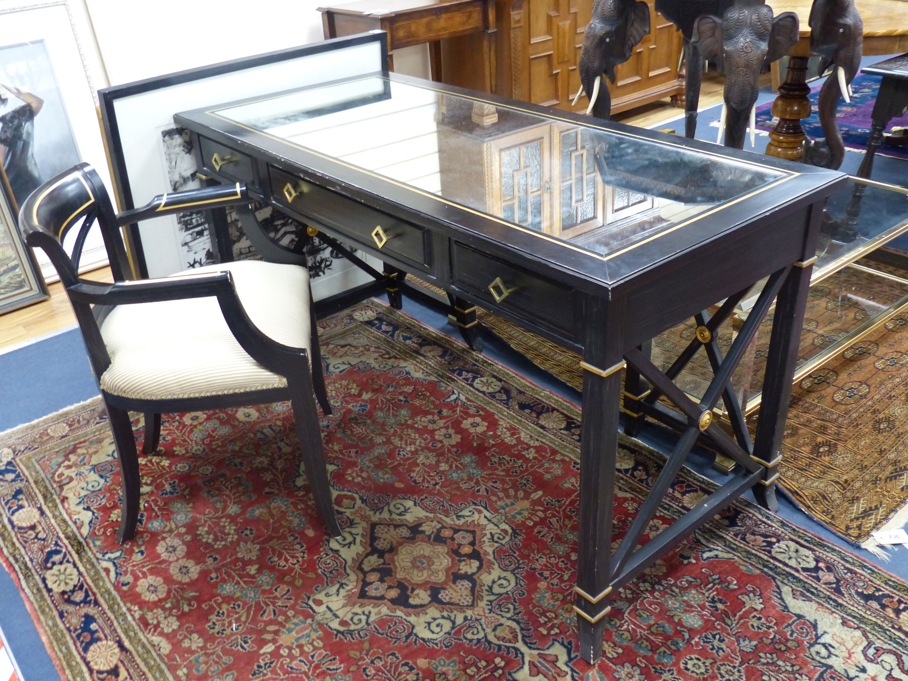 A Regency style ebonised mirrored dressing table, width 139cm, depth 64cm, height 75cm and elbow chair